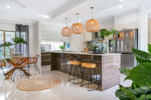 a kitchen with a island with bar stools at Escapades @ Palm Cove in Palm Cove