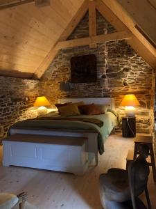 a bedroom with a bed in a stone wall at Au cœur du quartier historique in Lannion