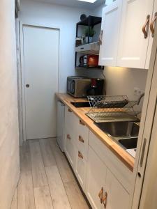 uma cozinha com armários brancos e um lavatório em Au cœur du quartier historique em Lannion