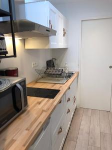 uma cozinha com armários brancos e um balcão com um micro-ondas em Au cœur du quartier historique em Lannion