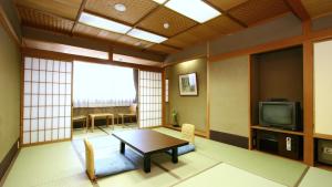 a living room with a table and a tv at Watazen Ryokan - Established in 1830 in Kyoto