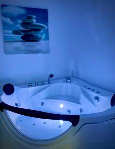 Albhotel Fortuna في ريديرش: حوض استحمام أبيض في غرفة بها لوحة