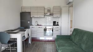 a kitchen with a green couch and a table at Appartamenti a Bardolino in Bardolino