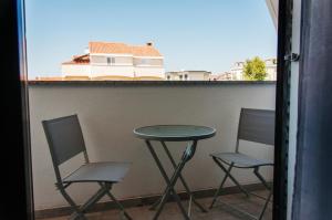 dwa krzesła i stół na balkonie w obiekcie Domus Albus w mieście Zadar