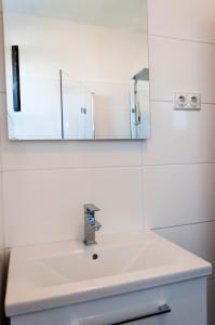 W łazience znajduje się biała umywalka i lustro. w obiekcie Domus Albus w mieście Zadar