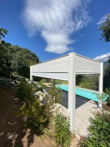 een wit paviljoen met een zwembad in een tuin bij Casa Fisolare in Capestrano