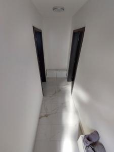 Un pasillo con dos puertas en una habitación blanca en Vehlovice Apartments, en Mělník
