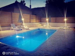 uma piscina num quintal à noite em House for rest Ruda em Grab