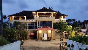 a large house with a lot of windows at Cherai Beach Palace in Cherai Beach