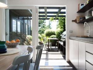 a kitchen with a table and chairs and an open door at Harts Lane Stag and Millies in Daylesford