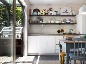 a kitchen with white cabinets and a table at Harts Lane Stag and Millies in Daylesford