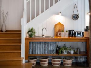 a kitchen under the stairs with a sink and plants at Edessa Lodge in Glenlyon