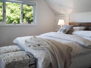a white bedroom with two beds and a window at Della Fonte- rural oasis, Daylesford charm in Daylesford