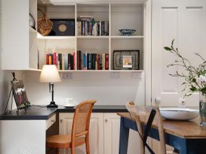una cocina con armarios blancos y una mesa con sillas. en Haiku, en Daylesford