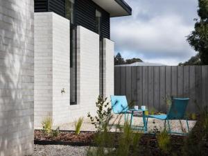 a patio with two chairs and a table in front of a house at Arenas North in Daylesford