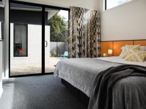 a bedroom with a large bed and a large window at Arenas North in Daylesford