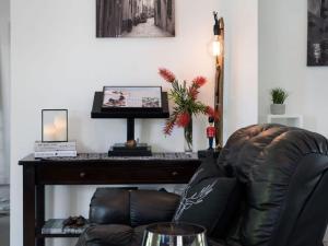 un fauteuil en cuir assis devant un bureau avec une télévision dans l'établissement Cottage 4A, à Daylesford