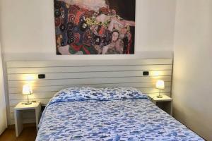 a bedroom with a bed and a painting on the wall at splendido appartamento vista mare in Levanto