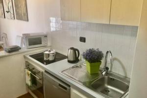 a kitchen with a sink and a stove and a microwave at splendido appartamento vista mare in Levanto