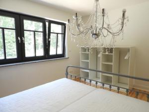 a bedroom with a bed and a chandelier at Großes Ferienhaus in Graal-Müritz in Graal-Müritz