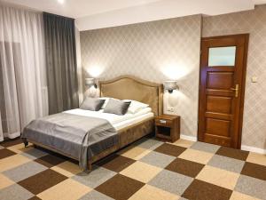1 dormitorio con 1 cama y una planta de tablero de ajedrez en Ośrodek Agroturystyczny Zacisze, en Giewartów
