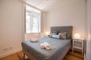 um quarto com uma cama grande com duas toalhas em Alfama Premium by Homing em Lisboa