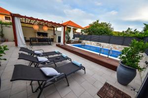 patio z krzesłami i basenem w obiekcie Villa Teuta ZadarVillas w mieście Zadar