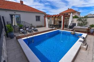 a swimming pool in the backyard of a house at Villa Teuta ZadarVillas in Zadar