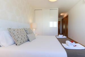 ein Schlafzimmer mit einem großen weißen Bett mit Handtüchern darauf in der Unterkunft Expo Delight by Homing in Lissabon