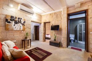 a living room with a red couch and a tv at BRG34 - Historical Vittoriosa Townhouse in Vittoriosa