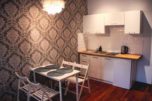 a kitchen with a table and chairs and a sink at Apartament Kattowitz in Katowice