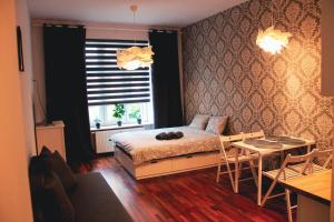 a bedroom with a bed and a table and a window at Apartament Kattowitz in Katowice