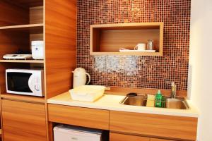 a kitchen with a sink, oven, microwave and dishwasher at FLEXSTAY INN Iidabashi in Tokyo