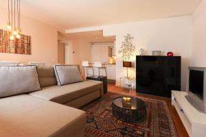 a living room with a couch and a flat screen tv at Downtown Chiado by Homing in Lisbon