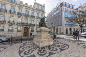a statue in the middle of a street in front of a building at Downtown Chiado by Homing in Lisbon
