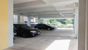two cars are parked in a parking lot at Suree Place Hostel in Hua Hin