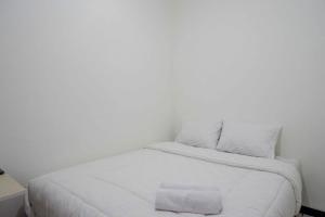a small bedroom with a bed with white sheets and pillows at Ambar Tosari Homestay at Desa Wisata Bromo in Pasuruan