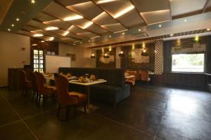 a restaurant with a table and chairs in a room at Regenta Inn Sambalpur, Farm Road in Sambalpur