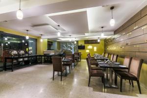 a dining room with tables and chairs in a restaurant at Magnus Star Residency in Pune