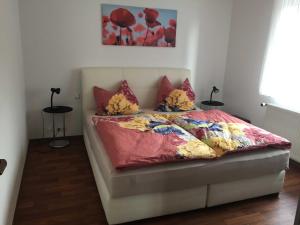 een bed met een roze dekbed en kussens erop bij Ferienwohnung Vereinswiek 95137 in Rhauderfehn