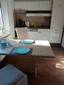 een keuken met een tafel met twee blauwe borden erop bij Ferienwohnung Vereinswiek 95137 in Rhauderfehn