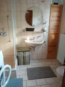 een badkamer met een wastafel en een douche bij Ferienwohnung Vereinswiek 95137 in Rhauderfehn