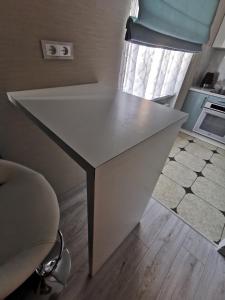 Una mesa blanca en una habitación con cocina en ALDO comfort en Ludza