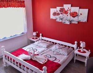 a red bedroom with a bed with a swan on it at Gostišče Trobej in Gornji Grad