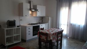 kuchnia z kuchenką i stołem z krzesłami w obiekcie Residence Condominio ROMA w mieście Eraclea Mare