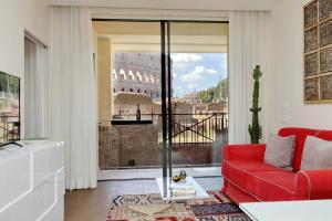 a living room with a red couch and a view of the coliseum at Luxury Domus Apartment 1 in Rome