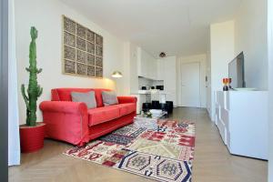 - un canapé rouge dans un salon avec un cactus dans l'établissement Luxury Domus Apartment 1, à Rome