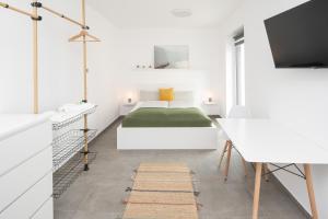 Un dormitorio blanco con una cama y un escritorio. en Nibelungen Apartments, en Worms