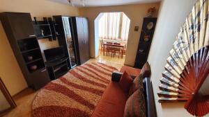 a living room with a bed and a dining room at Andi Apartament in Predeal