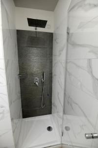 W łazience znajduje się prysznic ze szklanymi drzwiami. w obiekcie B&B La Dolce Vita w mieście Fondi +16 zdjęć